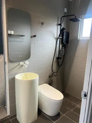a bathroom with a white toilet and a shower at Canning Home in Ipoh