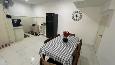 a dining room with a table and a black refrigerator at Memoir Perda in Bukit Mertajam