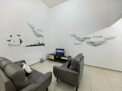 a living room with two couches and birds on the wall at Padang Serai Taman Ria 61 in Padang Serai