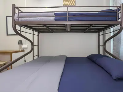 a bunk bed with blue pillows on top of it at Bed Station Guest House in Tanah Rata