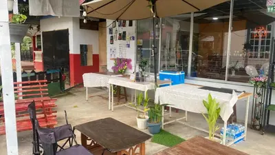 a restaurant with tables and chairs and an umbrella at Capital O 91189 Chalet Asyuk Maju in Baling