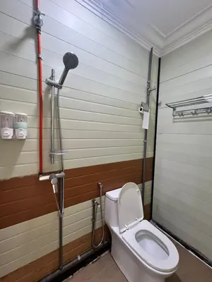a bathroom with a toilet and a microphone at Ting Brother Sg Klah Inn in Sungkai