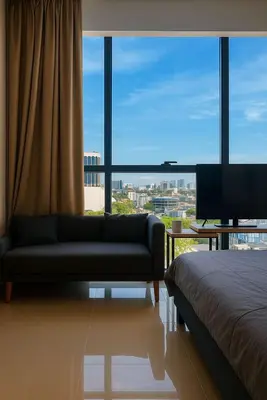 a living room with a couch and a large window at 2 Connecting Room, Kozi Square in Gua Sai