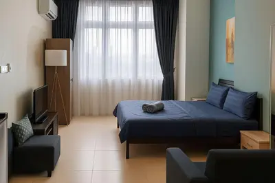 a bedroom with a blue bed and a television at 2 Connecting Room, Riverine Diamond in Gua Sai