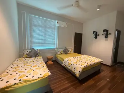 two beds sitting in a room with a window at SPICE Skyview Luxe Tunas 4B3B in Bayan Lepas