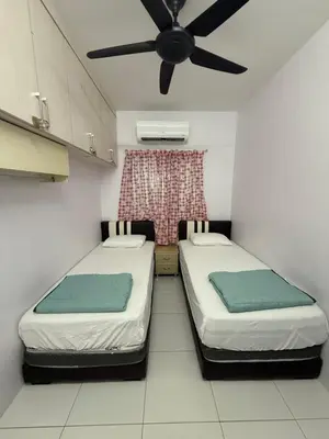 two beds in a room with a ceiling fan at DND Homestay Sitiawan in Sitiawan