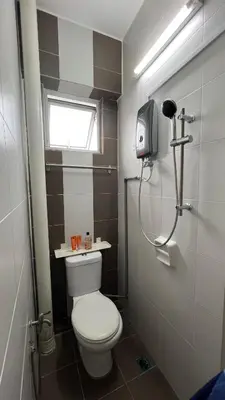 a small bathroom with a toilet and a window at Singah in Bukit Mertajam