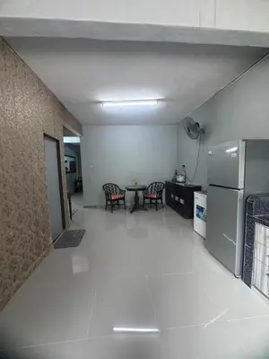 a kitchen and dining room with a table and a refrigerator at Homestay Pangkor Ann in Pangkor