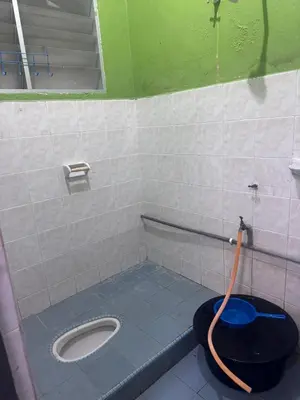 a bathroom with a toilet with an orange hose at Homestay Pangkor Ann in Pangkor