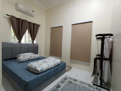 a bedroom with a blue bed with pillows on it at Homestay Omah D'Desa with pool in Kampong Telok Ru