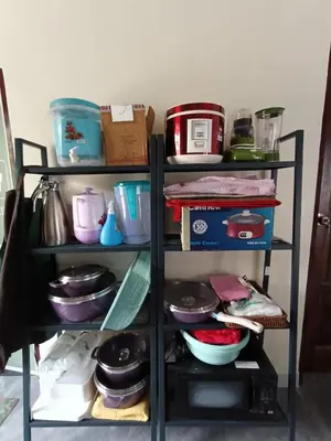 a shelf filled with pots and pans at Homestay Omah D'Desa with pool in Kampong Telok Ru
