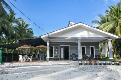 a small house on the beach at Homestay Omah D'Desa with pool in Kampong Telok Ru