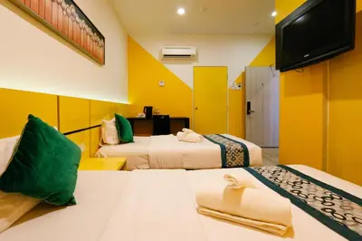 a hotel room with two beds and a flat screen tv at Golden Roof Hotel Sunway Ipoh in Ipoh
