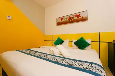 a bedroom with a bed with green and yellow walls at Golden Roof Hotel Sunway Ipoh in Ipoh