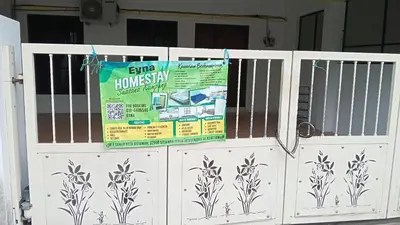 a white fence with a sign on it at Eyna Homestay in Sitiawan