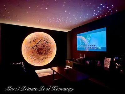 a room with a tv and a planet on the wall at Mars1 Private Pool Homestay in Ipoh