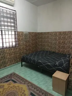 a bedroom with a bed in a room with a rug at Homestay Mariah in Ipoh