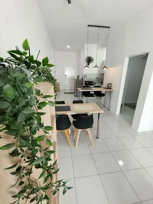 a living room with a table and chairs and a kitchen at Apartment In Ipoh, City View in Ipoh