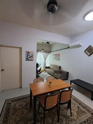 a living room with a table and a couch at Serra Homestay at Apartment Bukit Permata, Lumut in Lumut