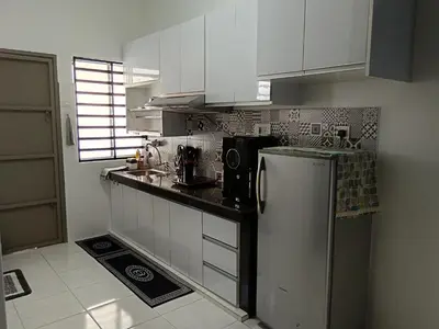 a kitchen with white cabinets and a refrigerator at ShaFA Homestay in Seri Iskandar