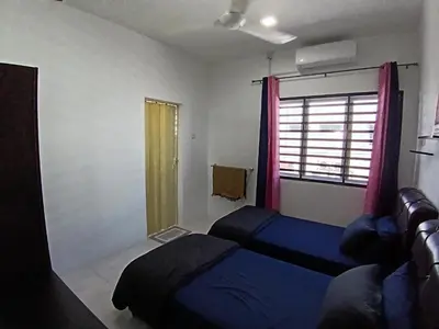 a bedroom with a blue bed and a window at ShaFA Homestay in Seri Iskandar
