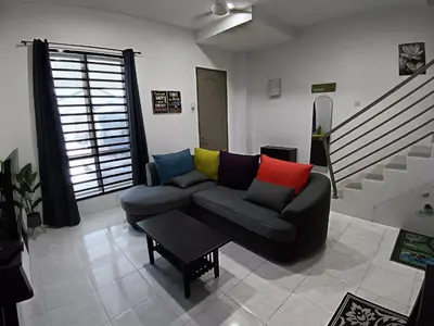 a living room with a couch with colorful pillows at ShaFA Homestay in Seri Iskandar