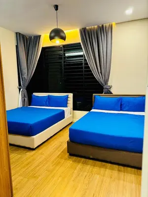 two beds in a room with blue pillows at Batu Ferringhi PoolBBQ 5minBeach Night Market20pax in Batu Ferringhi