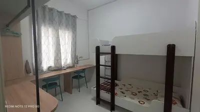 a room with a bunk bed and a table and chairs at ZIE HOMESTAY AT SOHO Seri Iskandar in Seri Iskandar