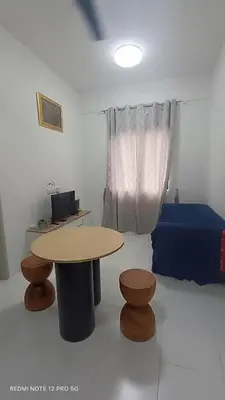 a room with a table and a bed at ZIE HOMESTAY AT SOHO Seri Iskandar in Seri Iskandar
