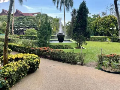 a fountain in the middle of a park with flowers at Batu Ferringhi Sri Sayang in Batu Ferringhi