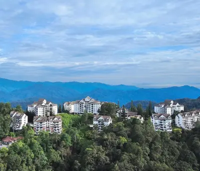 a group of houses on a hill with mountains in the background at A23A5 Silverpark HighFloorView in Bukit Fraser