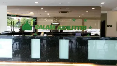 a restaurant with a black counter with chairs in it at The Corum View Hotel in Bayan Lepas