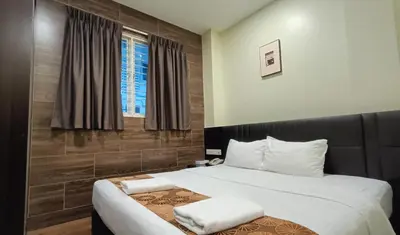 a bedroom with a large bed with white pillows at The Corum View Hotel in Bayan Lepas