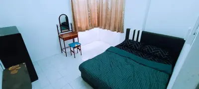 a living room with a couch and a desk at 3-Bedroom Homelike Apartment in Bukit Mertajam in Bukit Mertajam