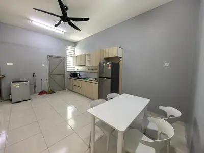 a kitchen with a white table and white chairs at Padang Serai Wangi Homestay 71 in Padang Serai