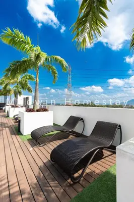 a deck with two chairs and a palm tree at Meritus Relax Holiday Homestay in Perai