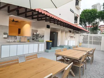 an outdoor patio with wooden tables and a kitchen at Mutiara Gurney bySOL at Genesis IVF, Gurney Paragon in George Town