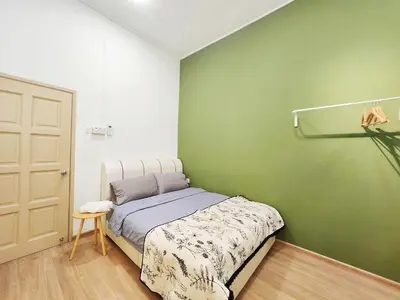 a bedroom with a bed and a green wall at Ipoh pasir puteh vibrant home 4br 15 pax in Ipoh