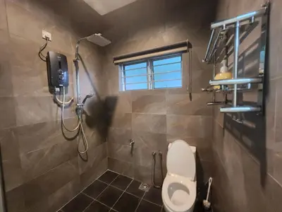 a bathroom with a shower and a toilet and a window at Ipoh Tambun pool villa 5br20pax bbq karaoke mahjong in Ipoh