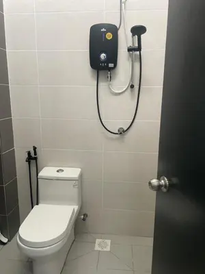 a bathroom with a toilet and a shower head at Homestay Cikgu Ina in Kampong Chepor