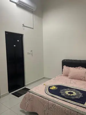 a bedroom with a bed and a black cabinet at Homestay Cikgu Ina in Kampong Chepor