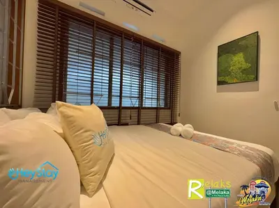 a bedroom with a bed with white sheets and a window at MalayaVilla 5R3B16Pax PrivatePool Karaok PlayGround in Gua Sai