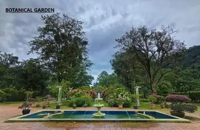 a fountain in the middle of a garden at Penang Hill Lodge in Ayer Itam
