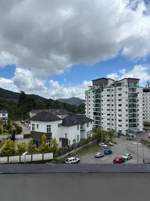 a group of apartment buildings with cars parked in a parking lot at Cool Escape Apartment Cameron Highlands in Cameron Highlands