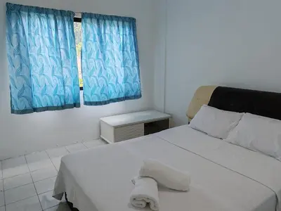a bedroom with a white bed with a towel on it at Pangkor Lot10 Vacation Studio in Pangkor