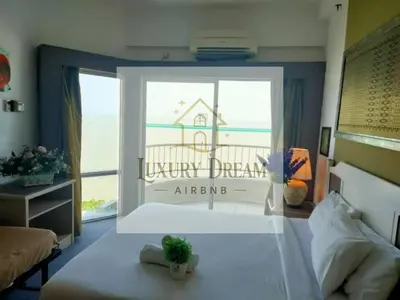 a bedroom with a large window with a view of the ocean at Luxury Dream Seaview in Tanjung Bungah
