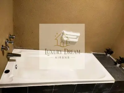 a white tub in a bathroom with a sign at Luxury Dream Seaview in Tanjung Bungah
