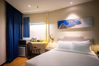 a hotel room with a bed and a desk and a bed at Embassy Hotel Georgetown in George Town