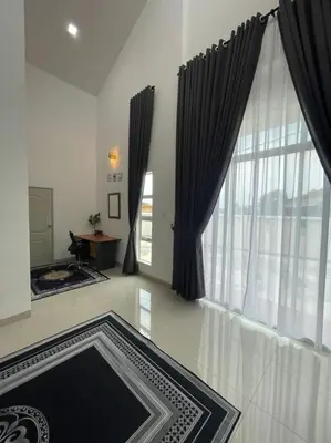 a living room with black curtains and a large window at The Indah Homestay Gerik in Gerik