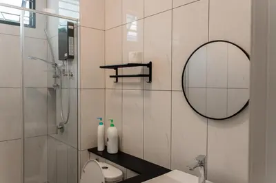 a bathroom with a shower and a sink and a mirror at SpaciousFun4BR Home 9Pax 3Bath Snooker ALMA in Bukit Mertajam